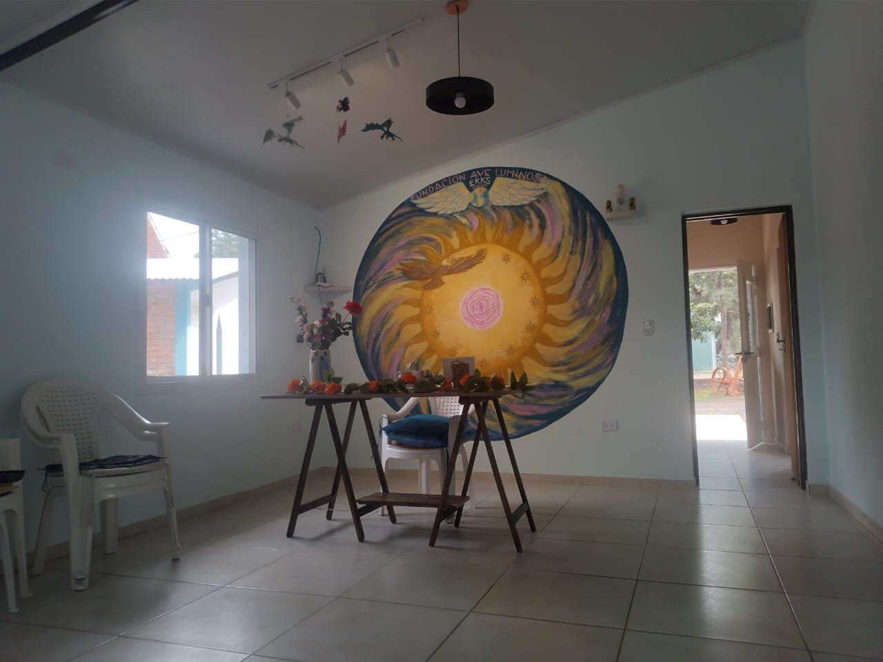 Salón de encuentros de la Fundación Ave Luminosa con mural del sol